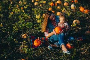 mor och dotter på en fält med pumpor foto