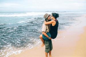 en kille och en flicka är kissing på en strand foto