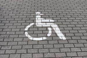 parkering utrymmen för Inaktiverad kunder. parkering massa med målad tecken av rullstol. foto
