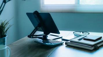 eleganta arbetsplats med telefon och läsplatta pc på tabell i Hem kontor, skön blå fyllning foto