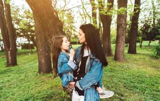 mamma och dotter på de gräsmatta ha roligt foto