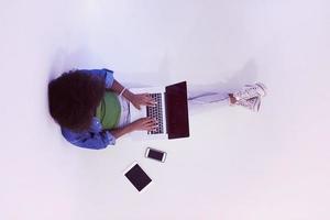 afrikansk amerikan kvinna Sammanträde på golv med bärbar dator topp se foto