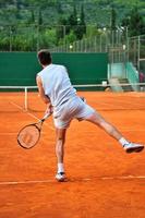 ett man spela tennis utomhus foto