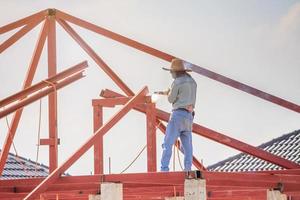 svetsarbetare som installerar stålramstruktur av hustaket på byggarbetsplatsen foto