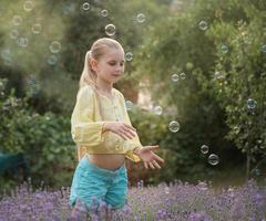 skön liten flicka i en fält med lavendel. foto