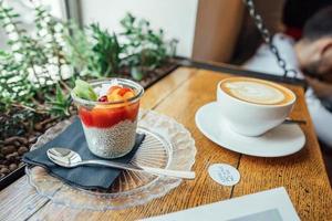 cappuccino med sked i kopp och efterrätt foto