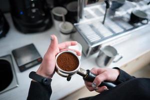 Barista innehav portafilter med jord kaffe foto