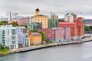 många-färgade byggnader på vid vatten i stockholm foto