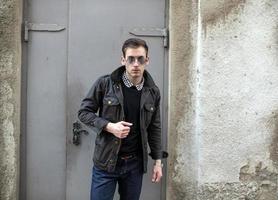 en man klädd i jeans på de bakgrund av dörrar foto