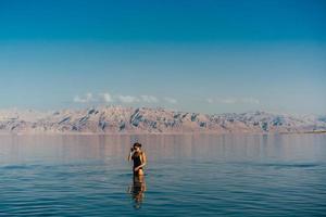 ung kvinna gående till död- hav, Israel foto