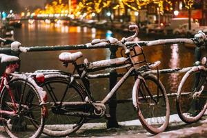 cyklar parkerad längs en bro över de kanaler av amsterdam foto