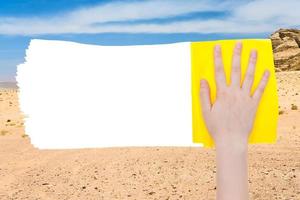 hand raderar sand av öken- förbi gul trasa foto