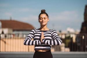 kvinna håller på med yoga övningar på hus tak i tidigt morgon- foto