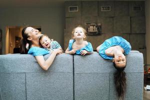 mamma, två döttrar och en liten son på de soffa foto