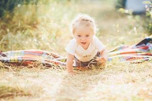 liten flicka krypande på de gräsmatta foto