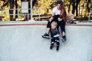 skön ung hipster mamma innehar henne liten son förbi de händer foto