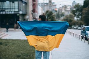 ung kvinna med nationell flagga av ukraina på de gata foto