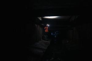 kvinna grävare med ficklampa utforskar de tunnel foto