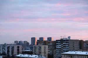 rosa moln i blå himmel över bostads- distrikt foto