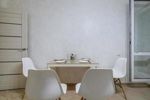 bekväm stolar och tabell med blommor i interiör de modern levande rum eller kök foto