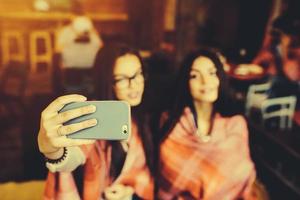 två nära vänner gör selfie på caféet foto