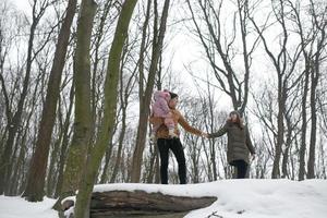 pappa och mamma med en liten dotter i de parkera foto