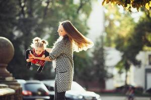 mor och liten dotter spelar i en parkera foto