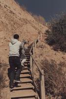 man och kvinna klättra de trappa tillsammans förbi de hav foto