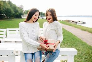 två vackra flickor som håller gåvor foto
