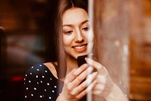 skön flicka talande på de telefon och leende. Instagram toning effekt foto