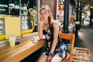 attraktiv ung caucasian kvinna Sammanträde i gata Kafé foto