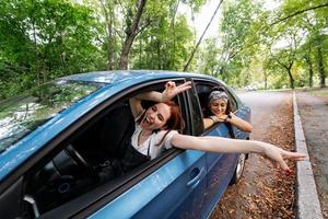 två flick lura runt om och skrattande tillsammans i en bil foto