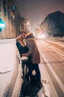 ung vuxen par kissing varje Övrig på snö täckt gata foto