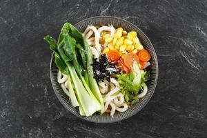 friska japansk maträtt, vegetarian udon yaki. udon soppa med bok choy, morot, majs, och grön lök i vitlök, ingefära och soja sås. foto