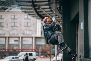 industriell klättrare i enhetlig och hjälm stiger foto