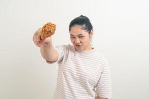asiatisk kvinna med stekt kyckling till hands foto