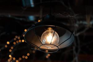 lampa hängande utanför på en mörk bakgrund. foto