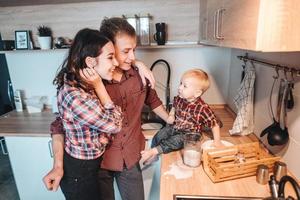 pappa, mamma och liten son laga mat en paj foto