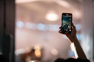 person stänga upp av inspelning video med smartphone under en konsert. foto