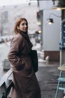 attraktiv kvinna i dike täcka på stad gata foto