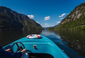 stilig ung kille kontroller en motorbåt på en berg sjö foto