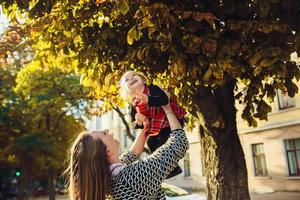 mor och liten dotter spelar i en parkera foto