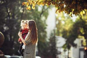 mor och liten dotter spelar i en parkera foto