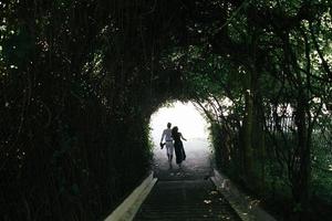 par som går genom tunneln av träd foto