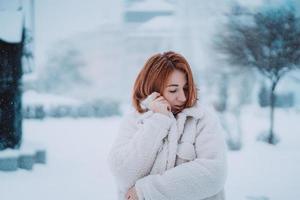 kvinna utanför på snöar kall vinter- dag foto