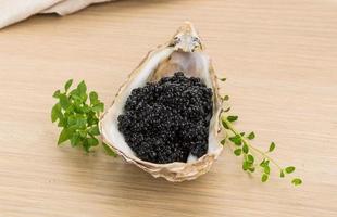 svart kaviar i en skål på trä bakgrund foto