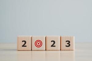 2023 ny år utmaning mål och mål, prestation och företag Framgång. 2023 ord på trä- block och röd dartboard ikon. Lycklig ny år 2023. företag och finansiell begrepp. foto
