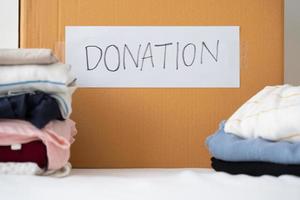 Kläder donation, delning, hoppas begrepp. Begagnade kläder på de kartong donation låda framställning till andra foto