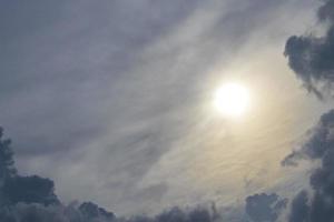 Sol lyser genom grå slöja moln omslag i Mexiko. foto