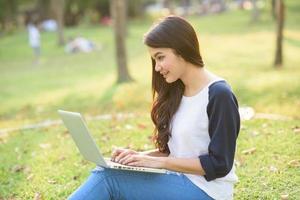 ung flicka med bärbar dator utomhus foto